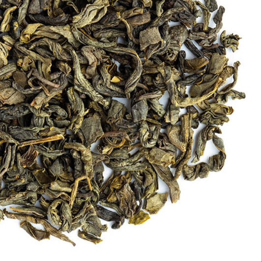 Dry green tea leaves with Grassroots Herb Supply logo on a white background